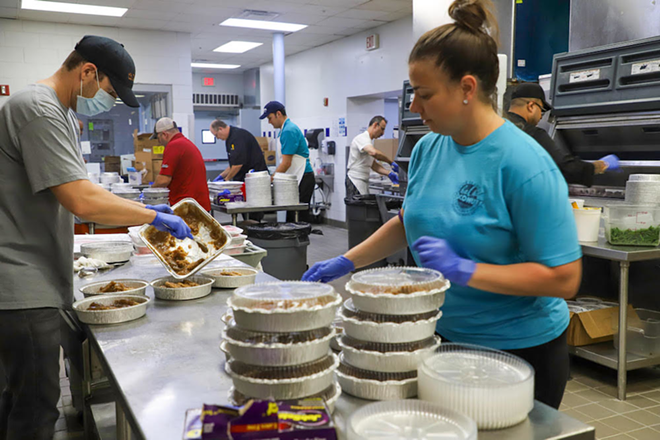 Andrea Gonzmart Williams, fifth generation of the Columbia Restaurant, packs meals for distribution to furloughed staff on Monday, March 30, 2020, at the Columbia in Ybor City. At left: Steve Stella, general manager of Ulele, plates portions of Salisbury steak. The meal distributions are part of efforts to support furloughed Columbia Restaurant Group workers at the company’s restaurants in Tampa, Clearwater, Sarasota, Celebration and St. Augustine. The restaurant group’s locations remain closed due to a state mandate that closed dine-in restaurants on March 20. - Columbia Restaurant Group