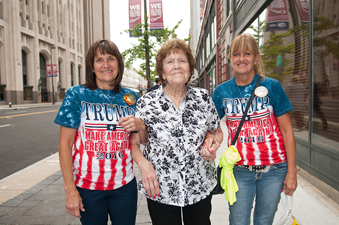 Kim (left) and Debbie walk down the street in Cleveland with their mom. The daughters wear matching pins which say "Bomb the Hell Out of Isis." - Joeff Davis