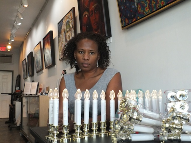 Gallerie 909 owner Carla Bristol readies electric candles for Ferguson vigil. - Ellen Kirkland