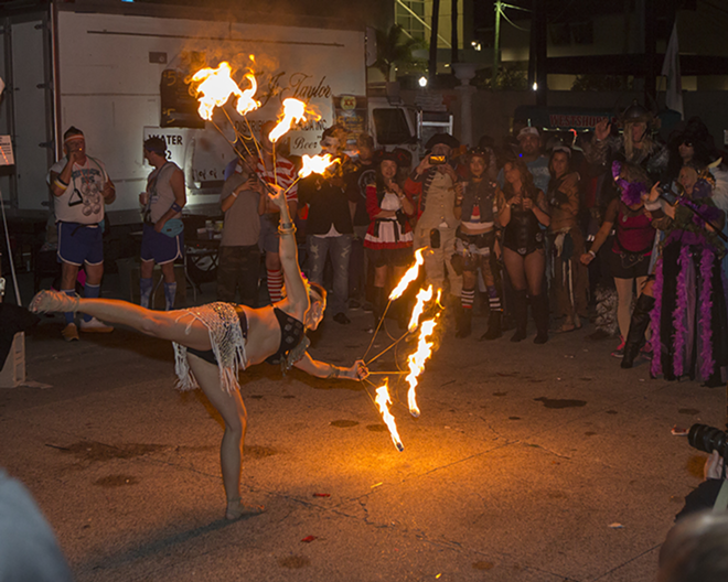 Chris Geyer dances with fire in the courtyard of the Cuban Club as part of the Guavaween celebration. - Chip Weiner