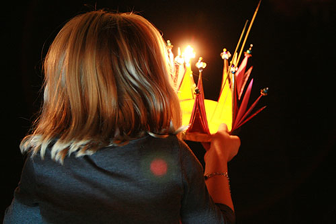 A small girl makes a wish before launching her krathong on the Palm River - Kimberly DeFalco