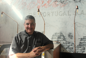 Executive Chef Ed Lowery in front of one of the Vitale Brothers murals inside the restaurant. - Meaghan Habuda