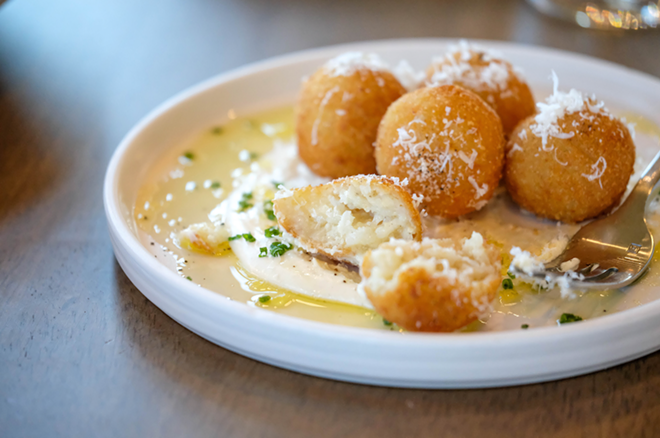 The arancini's breaded exterior yields not to a typical meat filling, but to a surprising liquid center of quattro formaggi (four cheeses) with a creamy pool of more cheese dotted with cracked pepper and minced chives surrounding the golden orbs. - Melissa Santell