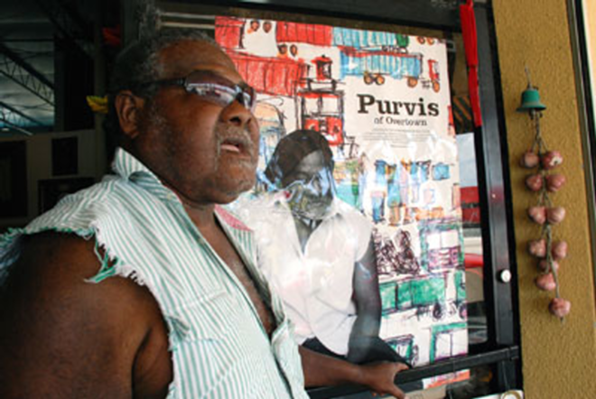 BIG MAN IN MIAMI: Purvis Young stands next to a poster of a documentary about him, Purvis Of Overtown.- - Megan Voeller