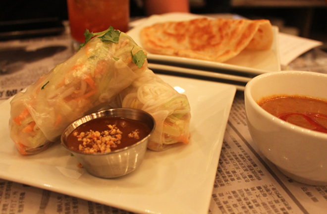 Summer rolls with peanut dipping sauce alongside roti canai in the back. - Meaghan Habuda