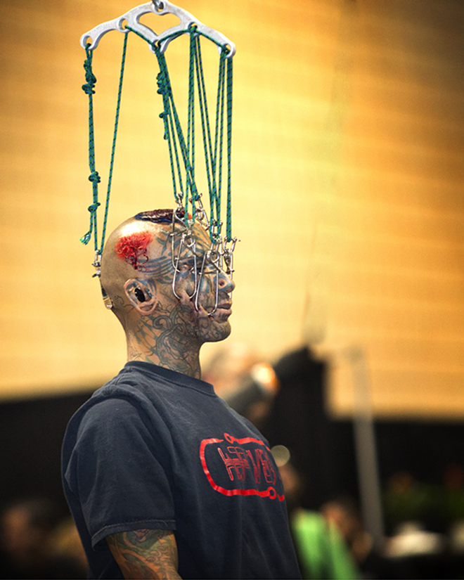 HANGIN' OUT: Suspension artist Supa  is suspended in mid air with hooks through his face. - Chip Weiner