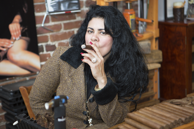 SMOKIN’: Odelma Matos rolls and smokes in style at her shop, La Faraona Cigars. - Chip Weiner