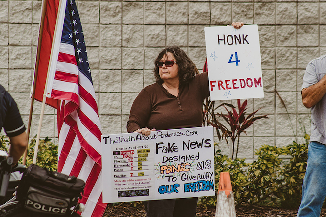 An anti-lockdown protester outside WVTV in Tampa, Florida on April 26, 2020. - Yvonne Gougelet