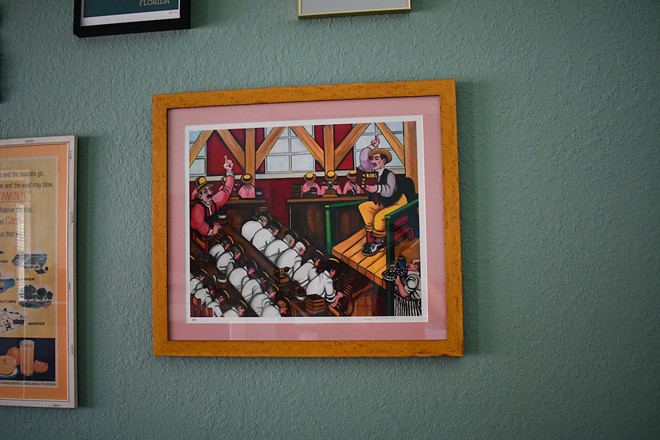 A Ferdie Pacheco print of a lector reading to cigar rollers hangs from Hurtak's wall. - Justin Garcia