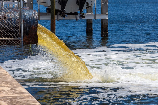 Raw untreated yellow water or sewage being pumped into a blue lake - Hollywood, Florida. - Photo via Adobe Images