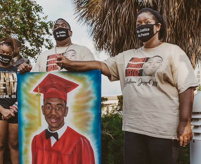 Andrew Joseph's parents hold a sign of their son, who died after being ejected from the Florida State Fair by HCSO in 2014. - Yvonne Gouglet