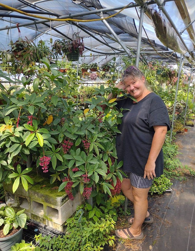 Jennifer Hebert poses next to plants in her nursery. - Joseph Hebert