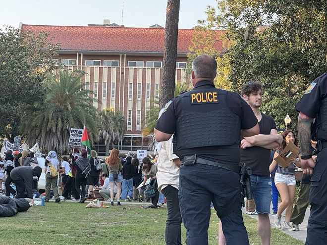 An unidentified University of Florida campus police officer watches over about 50 pro-Palestinian protesters who demonstrated on campus Thursday, April 25, 2024, for a second consecutive day.  There was no violence or police response – a contrast to what was happening at some other college campuses around the U.S. - Photo by Amanda Friedman/Fresh Take Florida