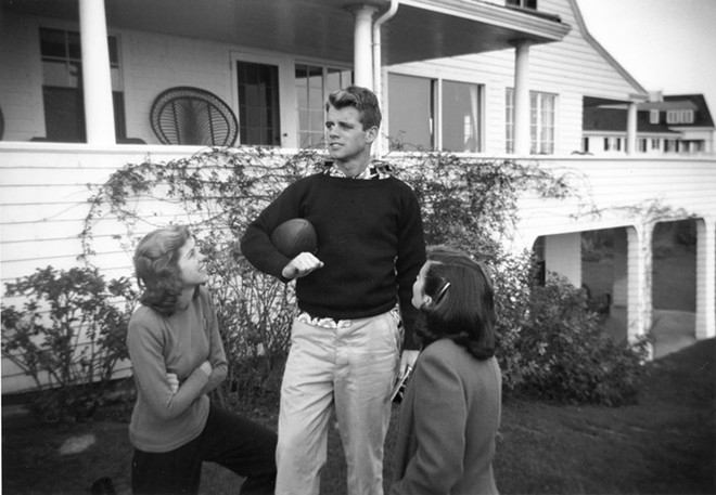 Robert F. Kennedy holds a football in Hyannis Port, Massachusetts with sisters Eunice Kennedy and Jean Kennedy. - John F. Kennedy Presidential Library and Museum, Boston