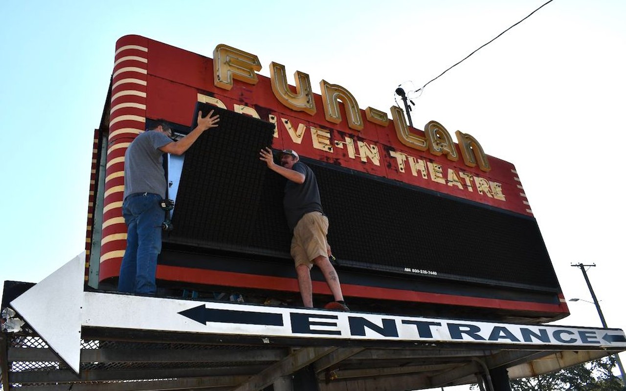 Crab Devil collective members examine Fun-Lan's front entrance sign as dismantling begins.
