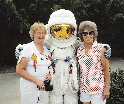 Tourists to the Kennedy Space Center in Orlando, Florida posing with a pretend astronaut in an Apollo spacesuit. Administered by NASA, KSC is a major tourist attraction for tourists to the Orlando area. Two million people visited in 1981, making KSC the fourth most popular destination for Florida tourism. 1981.