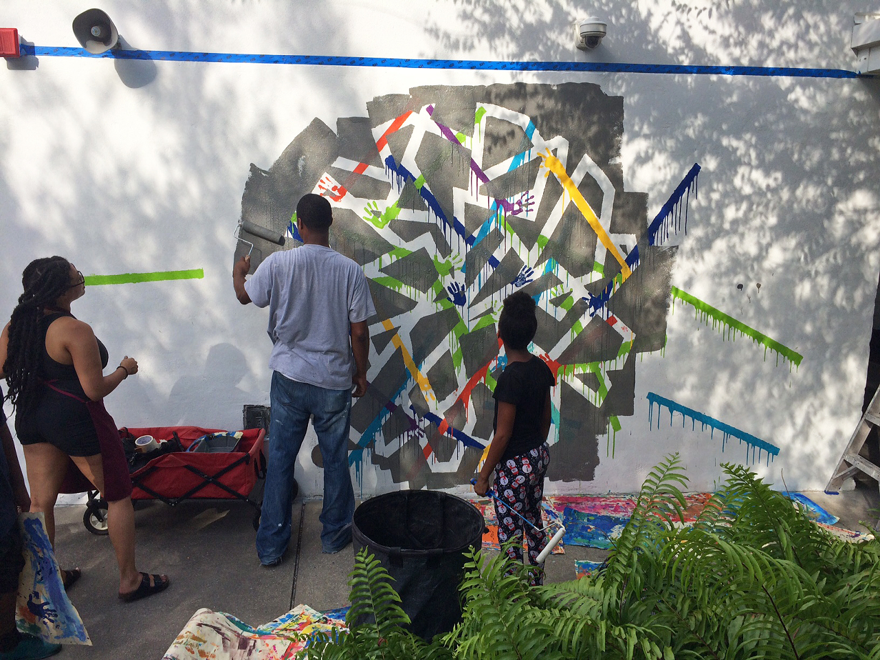 The next layer: Ya and partner work on their portion of the mural.